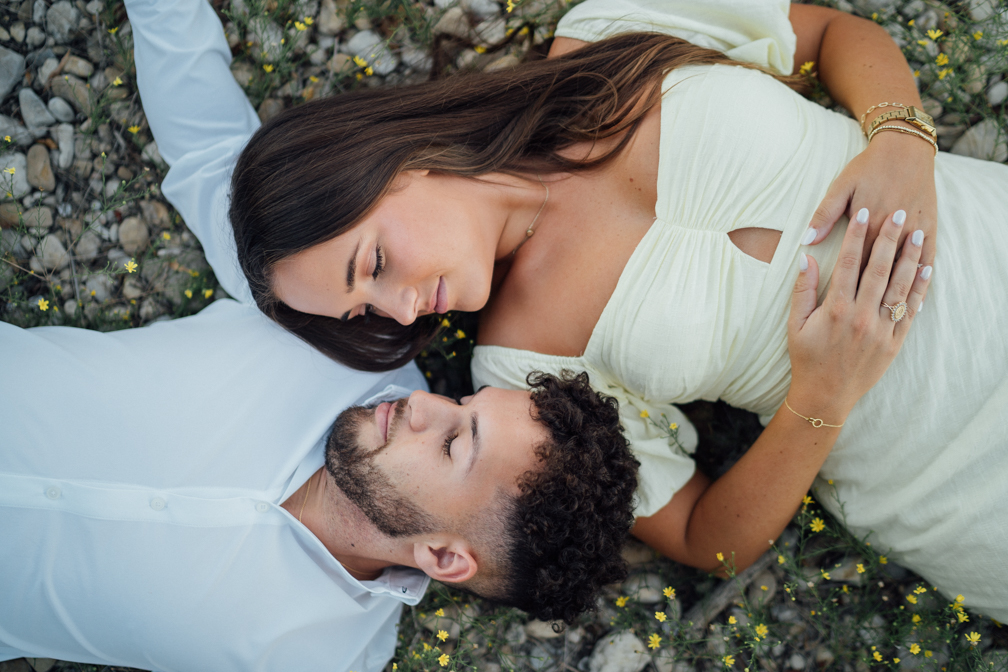 Top view of a couple lying on the ground looking at each other during an engagement session